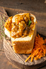 Curry of meat and potatoes with spices in white bread, bunny chow South African fast food.