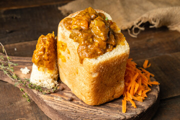 Beef and vegetable curry served in white bread, South African fast food.