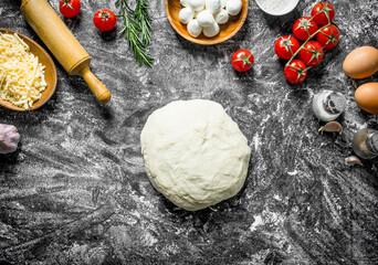 Raw pizza. Dough with different ingredients for cooking homemade pizza.
