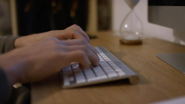 Male hands typing on a computer keyboard