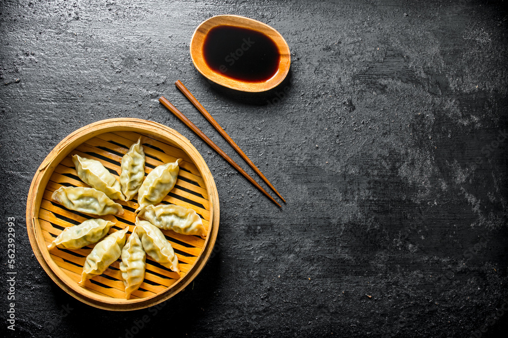 Poster fragrant chinese gedza dumplings in a bamboo steamer.