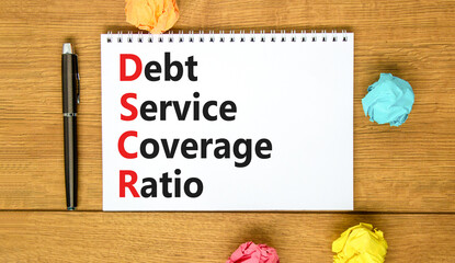 DSCR debt service coverage ratio symbol. Concept words DSCR debt service coverage ratio on white note on beautiful wooden background. Business DSCR debt service coverage ratio concept. Copy space.