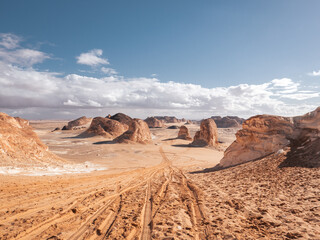 The view of car tracks in the sand of Valley of Agabat, White Desert, Egypt.