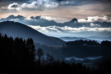 Amazing landscape of Tatra Mountains in the clouds and  moody and misty dark forest under the...