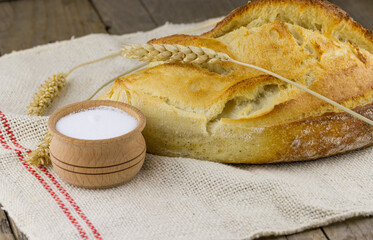 Freshly baked white bread with salt and spikelets of wheat