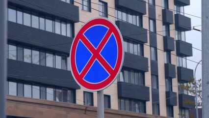 The road sign "Stop is prohibited" stands on the road where it is forbidden to leave and park cars. Shot in motion 