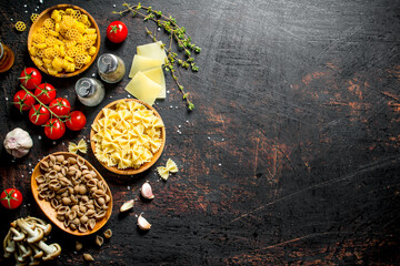 Different types of raw paste in bowls with tomatoes, garlic and mushrooms.