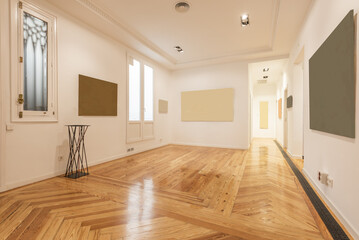 Large empty room with white wooden doors and windows with a pine wood floor and plain white walls