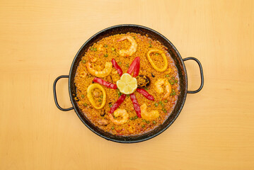 Some wonderful Spanish seafood and fish paella with roasted red peppers and a lemon in the center to garnish