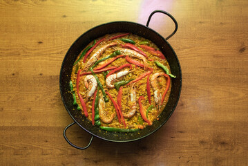 Wonderful Spanish seafood and fish paella with roasted red and green peppers in strips with lots of prawns