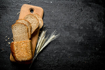 Sliced bread on a cutting Board with spikelets.