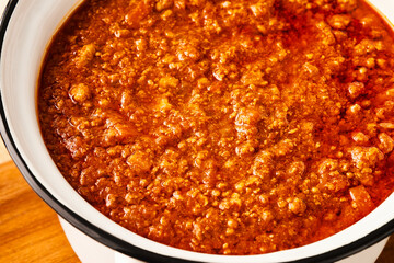Close-up of fresh BOLOGNESE SAUCE in a white saucepan. High angle view. - obrazy, fototapety, plakaty