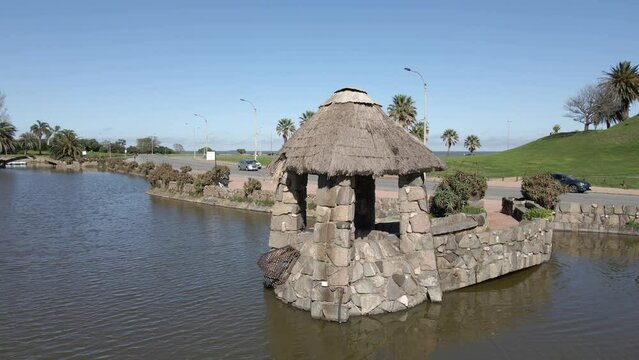 Pasarela con refugio de piedra sobre lago en peque&ntilde;o lago