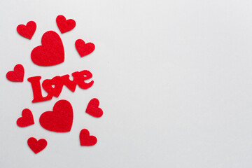 Felt word love with hearts on color background, top view