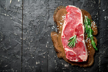 Raw beef steaks with fragrant rosemary. - 562403192
