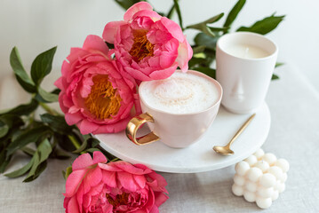 Cup with cappuccino, flowers peony, morning concept, soy candle, woman's day