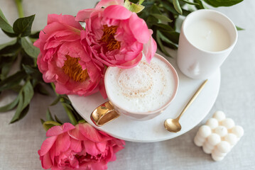 Cup with cappuccino, flowers peony, morning concept, soy candle, woman's day