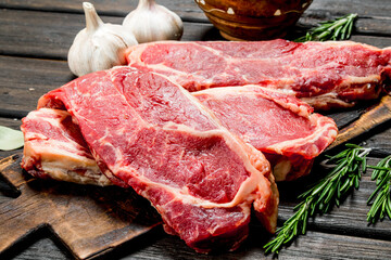 Raw beef steaks with salt and spices.