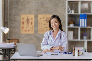 Asian female doctor working at desk with online consultation on medicines and treatments in doctor...