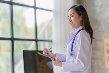 Asian female doctor working at desk with online consultation on medicines and treatments in doctor...