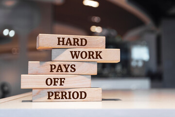 Wooden blocks with words 'Hard Work Pays Off Period'. Business concept