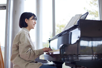 ピアノを演奏する若い日本人女性 © west_photo