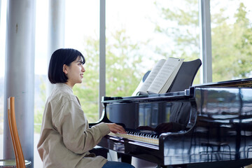 ピアノを演奏する若い日本人女性 © west_photo