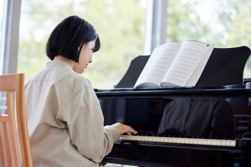 ピアノを演奏する若い日本人女性 © west_photo