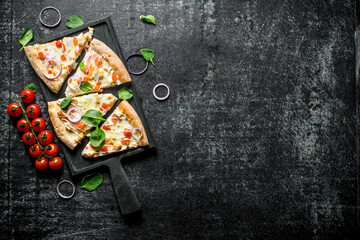 Slices of pizza with tomatoes on a branch and spinach.