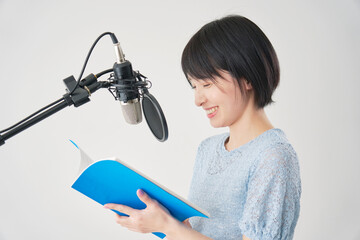 アフレコをする声優の女性　白背景