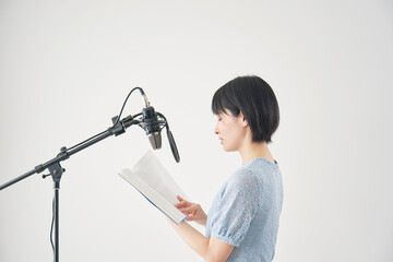 アフレコをする声優の女性　白背景