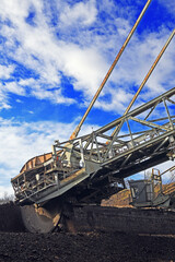 Bucket-wheel excavator during excavation at the surface mine. Huge excavator on open pit mine.