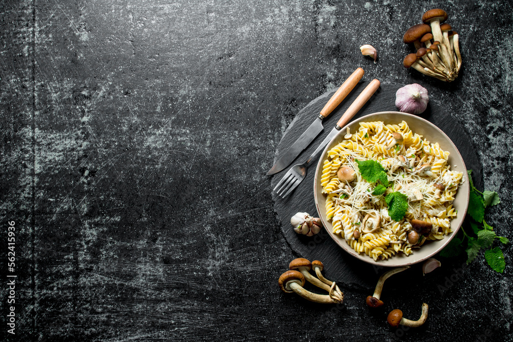 Sticker fusilli pasta in a bowl of mushrooms and garlic.