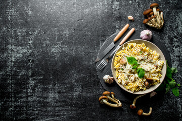 Fusilli pasta in a bowl of mushrooms and garlic.