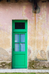 Puerta antigua verde en muro desgastado