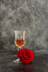 Close up two glasses of liquor and a rose on a black background.