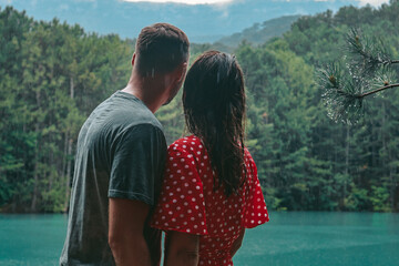 A loving couple stands near the lake. Lovers walk in nature.