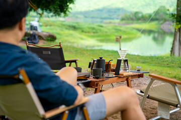 Drip coffee makers on outdoor camping table. Group of People enjoy outdoor lifestyle travel nature...