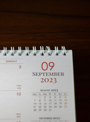Top view shot of a 2023 calendar, "September page". Selective focus shot of a calendar, focused on "09, September, 2023".