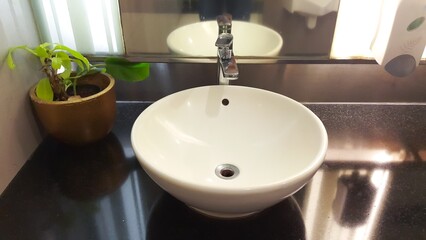 Round ceramic wash basin. Stylish sink bowl and tap. Bathroom interior.