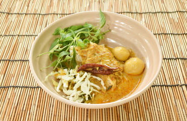 rice noodles on bowl with spicy  fish curry sauce and fresh vegetable