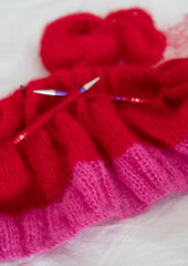 Bright pink and red mohair yarn hand knitted sweater with stitches including stocking stitch and rib, knitted on circular needles. 
