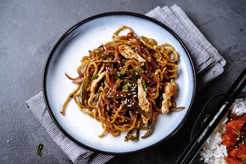 Chicken Lo mein noodles topped with toasted sesame seeds and spring onions