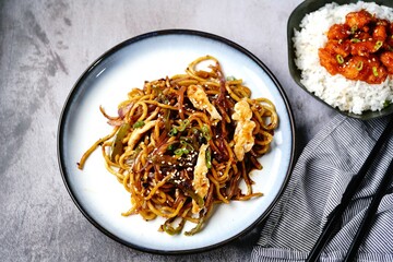 Chicken Lo mein noodles topped with toasted sesame seeds and spring onions