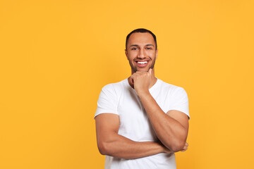Portrait of happy African American man on orange background. Space for text