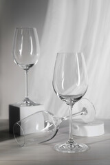 Empty wine glasses and cube on white wooden table