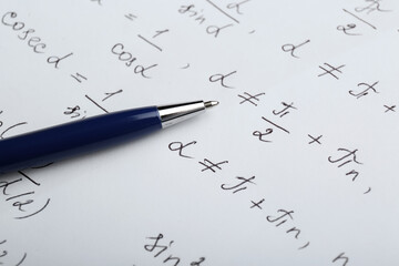 Fototapeta premium Sheet of paper with different mathematical formulas and pen, closeup