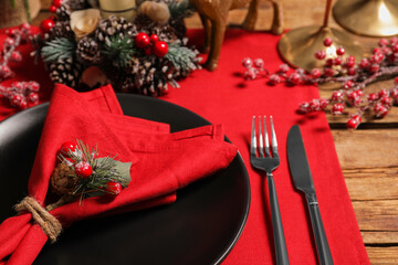 Festive place setting with beautiful dishware, cutlery and decor for Christmas dinner on wooden table