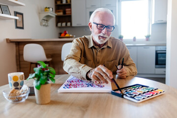 Senior Caucasian man painting at her home.