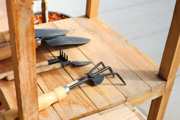 Gardening tools on wooden table in greenhouse.